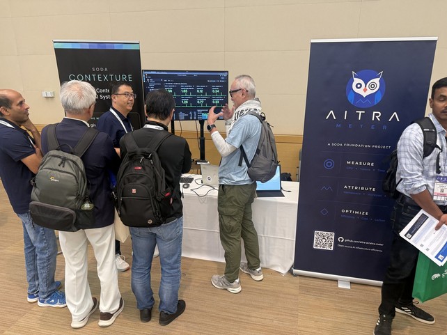 Attendees at the Aitra Meter booth watching the live dashboard